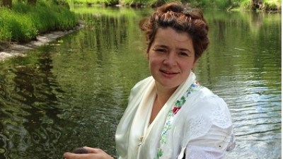 Nahaufnahme von Fährfrau Yvonne in Tracht mit Ihrem Paddel auf Ihrem Kahn